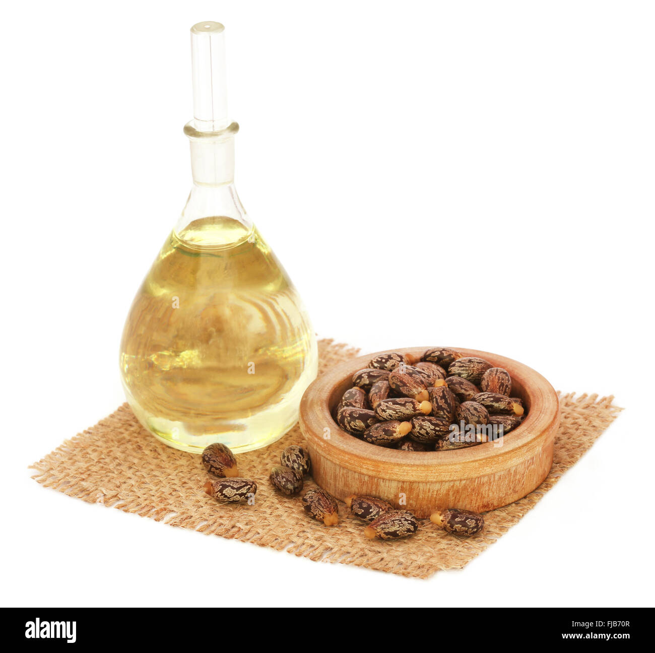 Rizinusöl mit Bohnen auf Sack auf weißem Hintergrund Stockfoto