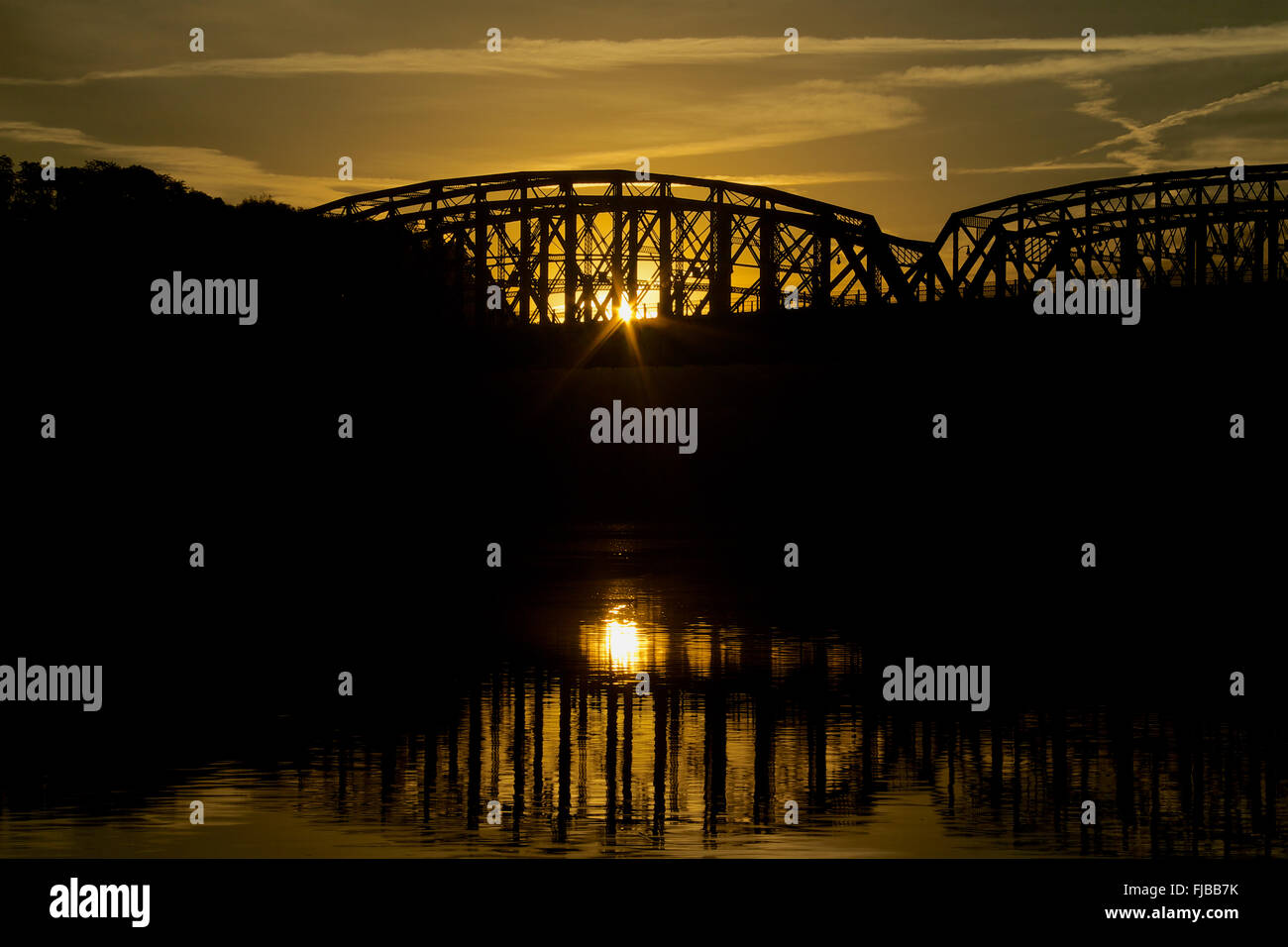 Die Sonne geht hinter der Hot Metall Brücke, eines Fachwerkbinders durchquert den Monongahela Fluss in Pittsburgh, PA. Stockfoto