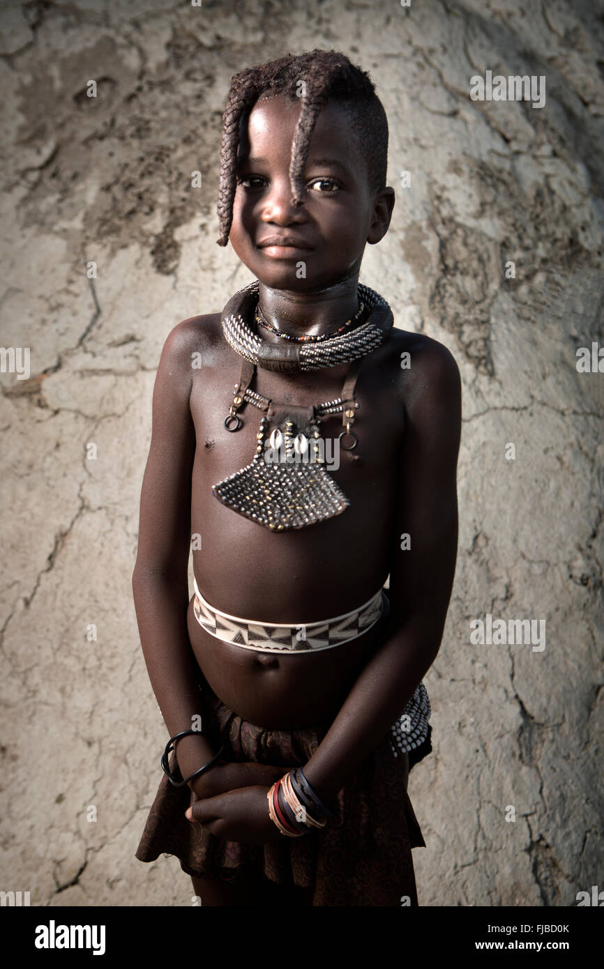 Ein Himba-Mädchen zeigt ihre traditionelle Verzierungen. Stockfoto