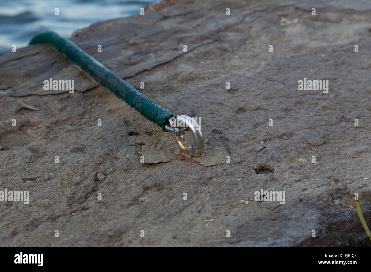 Schlauchleitung erstreckt sich eine Kette gefesselt, um eine marine Edelstahl-Ringschraube Stockfoto