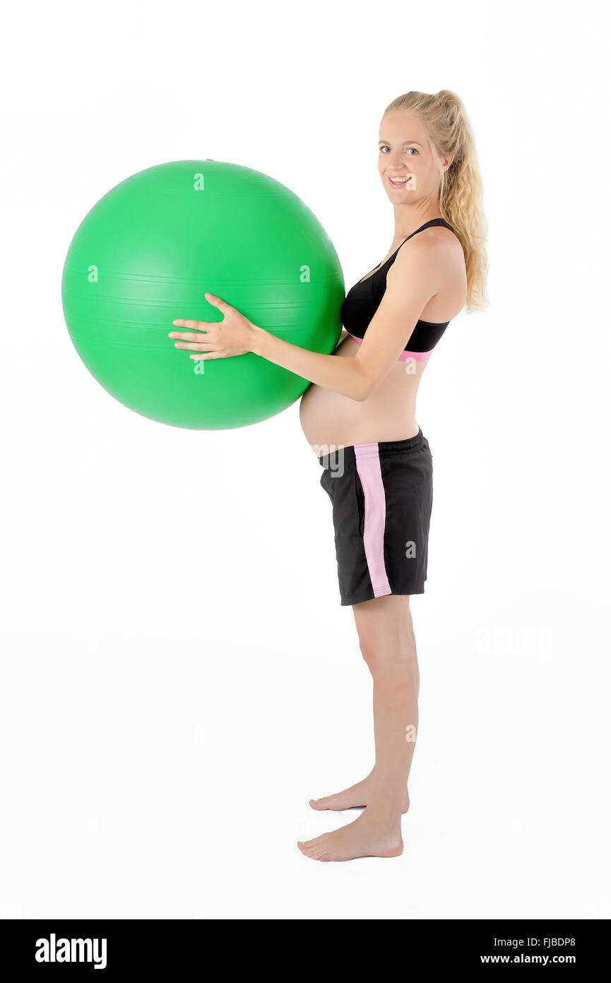 Schwangere Frau mit Balance Yoga Ball gegen Bauch. Stockfoto