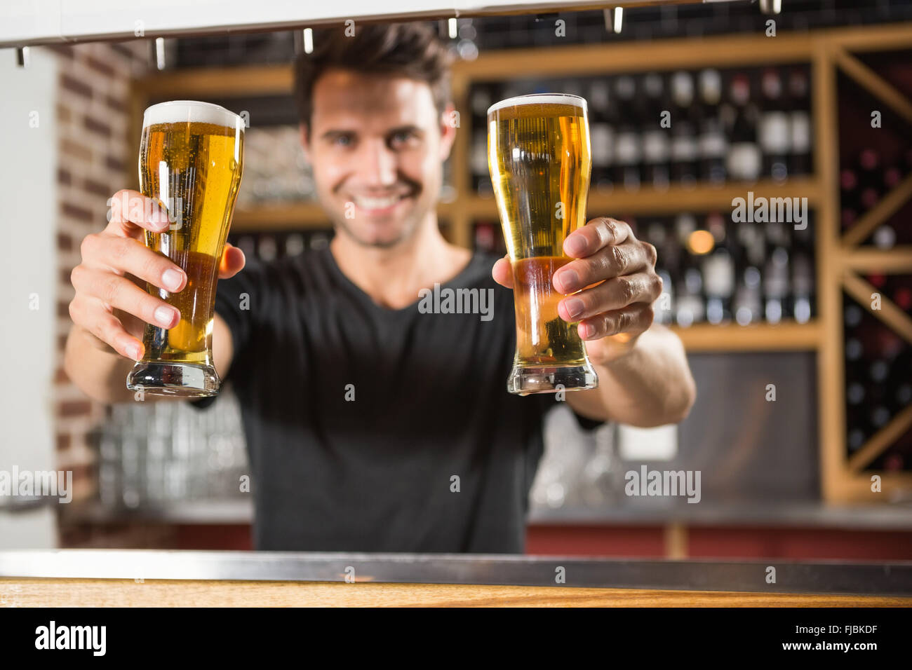 Gut aussehend Barkeeper hält einen Pint Bier Stockfoto