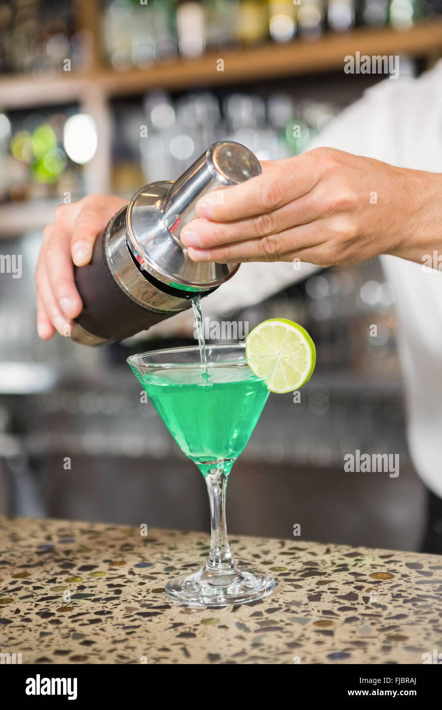 Gut aussehend Barkeeper einen Cocktail in ein Glas gießen Stockfoto