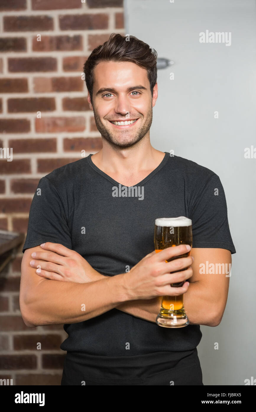 Gut aussehender Mann hält einen Pint Bier Stockfoto