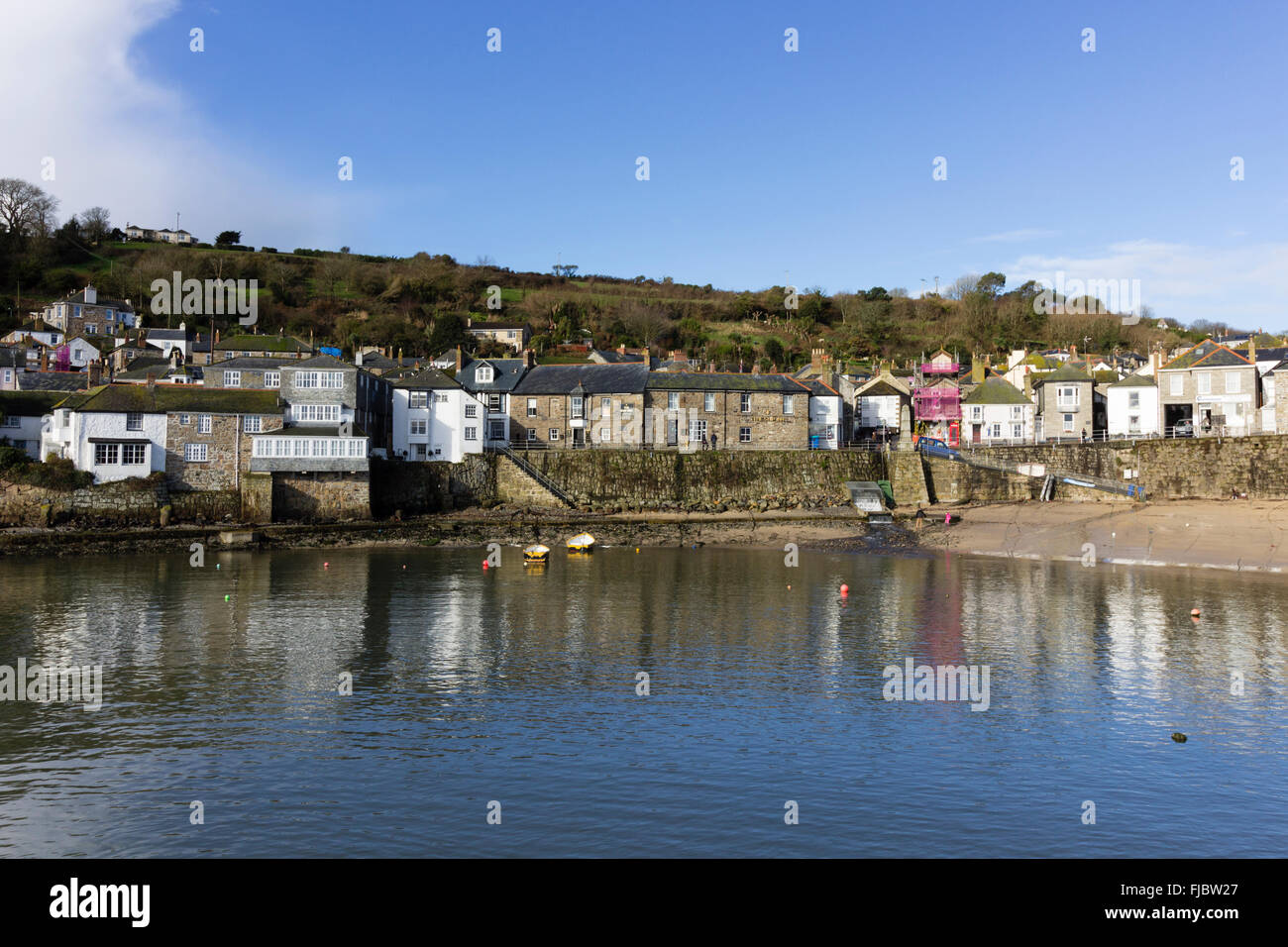 Der Hafen und die Hafenpromenade am Mousehole, Cornwall, UK genießen Spätwinter Sonnenlicht im Februar 2016 Stockfoto