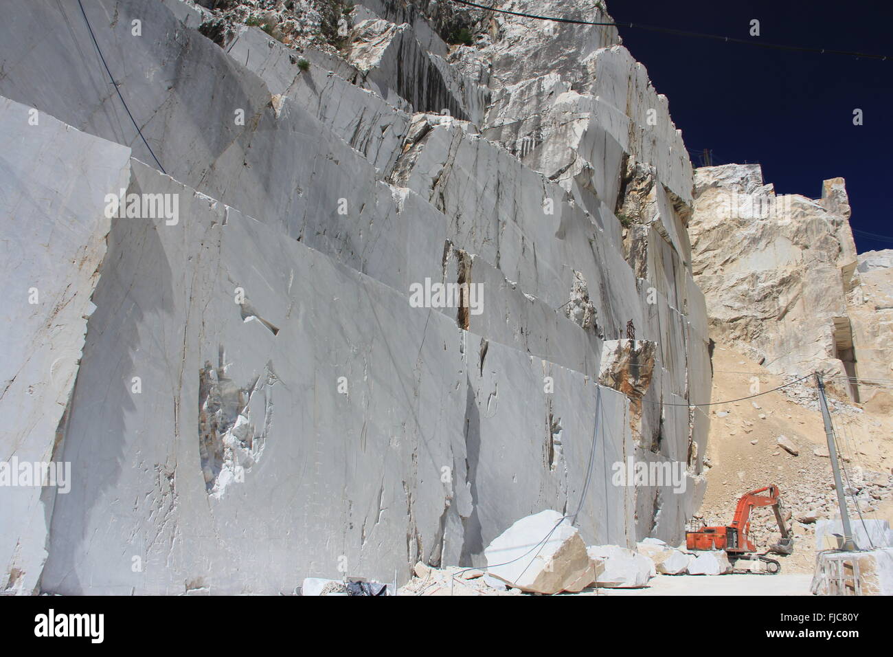 Solide Marmor Felswand mit Digger, Carrara Italien Stockfoto