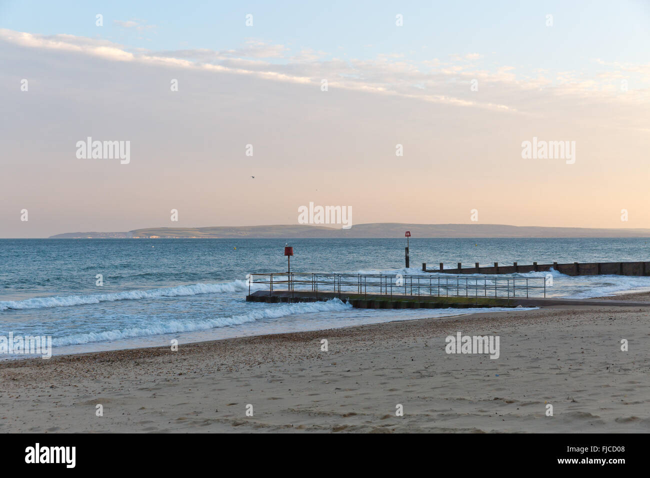 ein Abendlicht, Blick auf einem Steg am Strand mit Sand und ein Flugzeug-Cloud auf einem Winkel getroffen Stockfoto