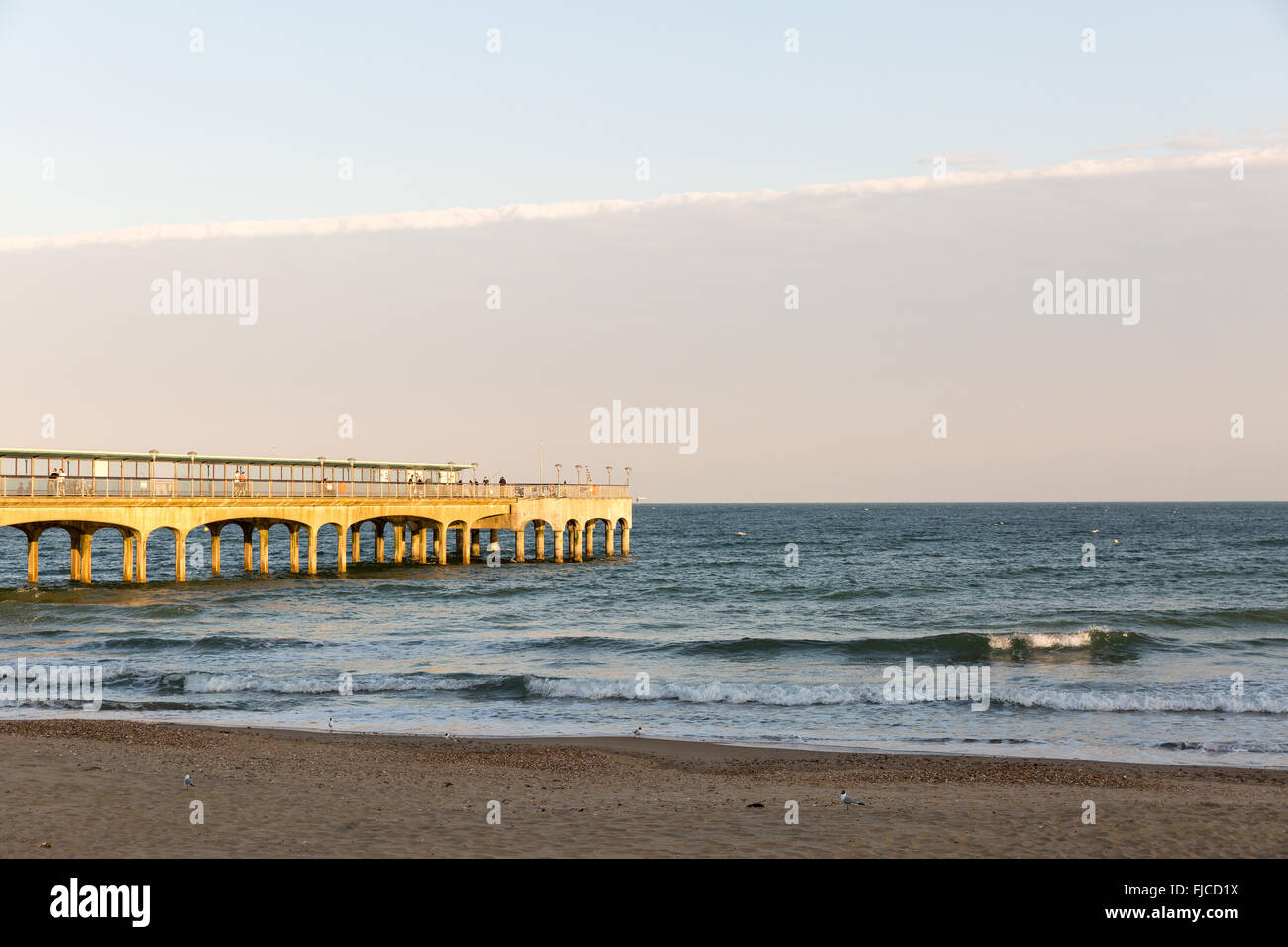 Goldene Abendlicht am Strand an einem Pier in Europa an einem Sommertag Stockfoto