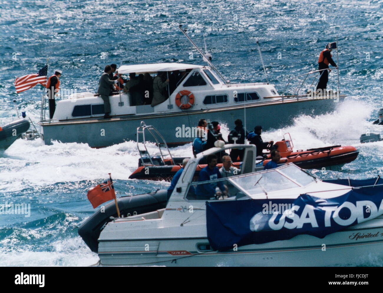 AJAX-NEWS-FOTO. JUNI 1994. SPITHEAD, ENGLAND. -JUBILÄUM PRÄSIDENT - US-PRÄSIDENT BILL CLINTON, UMGEBEN VON SECRET SERVICE MEN UND VIPS, SEGELT DURCH EINE ABGEHACKTE SOLENT EINGESCHIFFT AUF EINEM U.S.NAVY FRÄSER (AM WEITESTEN ENTFERNTEN BOOT FLYING STARS AND STRIPES FLAG.) WÄHREND DIE 50. D-DAY JUBILÄUM SPITHEAD FLOTTE ÜBERPRÜFEN. MEDIEN-BOOTE UMGEBEN DEN CUTTER. FOTO: JONATHAN EASTLAND/AJAX REF: CLINTON 9406 36 Stockfoto