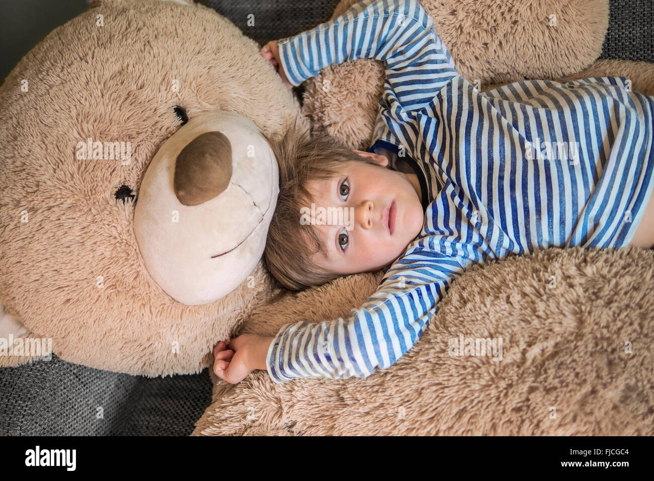 Nettes Kind hängen mit seiner riesigen Teddybär Stockfoto