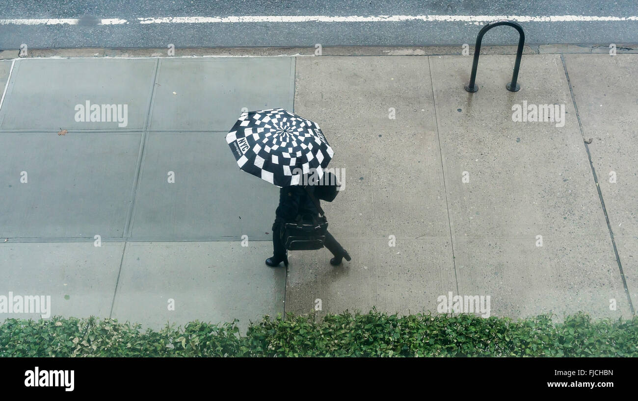 Eine Frau kommt in Chelsea mit ihrem Schirm in den Winterregen in New York auf Mittwoch, 24. Februar 2016. Starker Regen und Wind ist die Wetterfrösche Prognosen für heute.  (© Richard B. Levine) Stockfoto