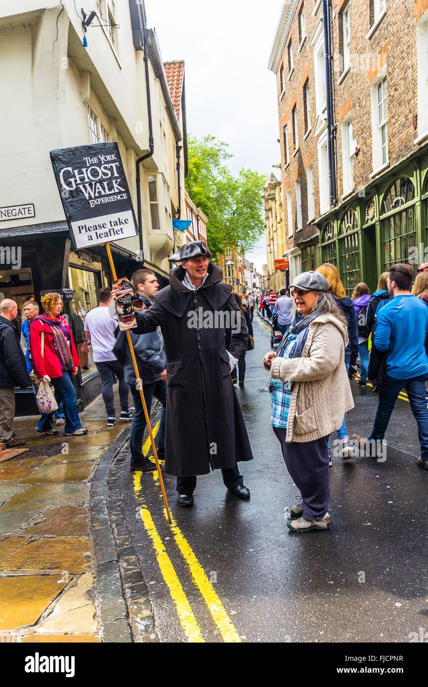 Alte Straßen von York, England, Vereinigtes Königreich, The York Ghost walk Mann lädt Touristen. Stockfoto