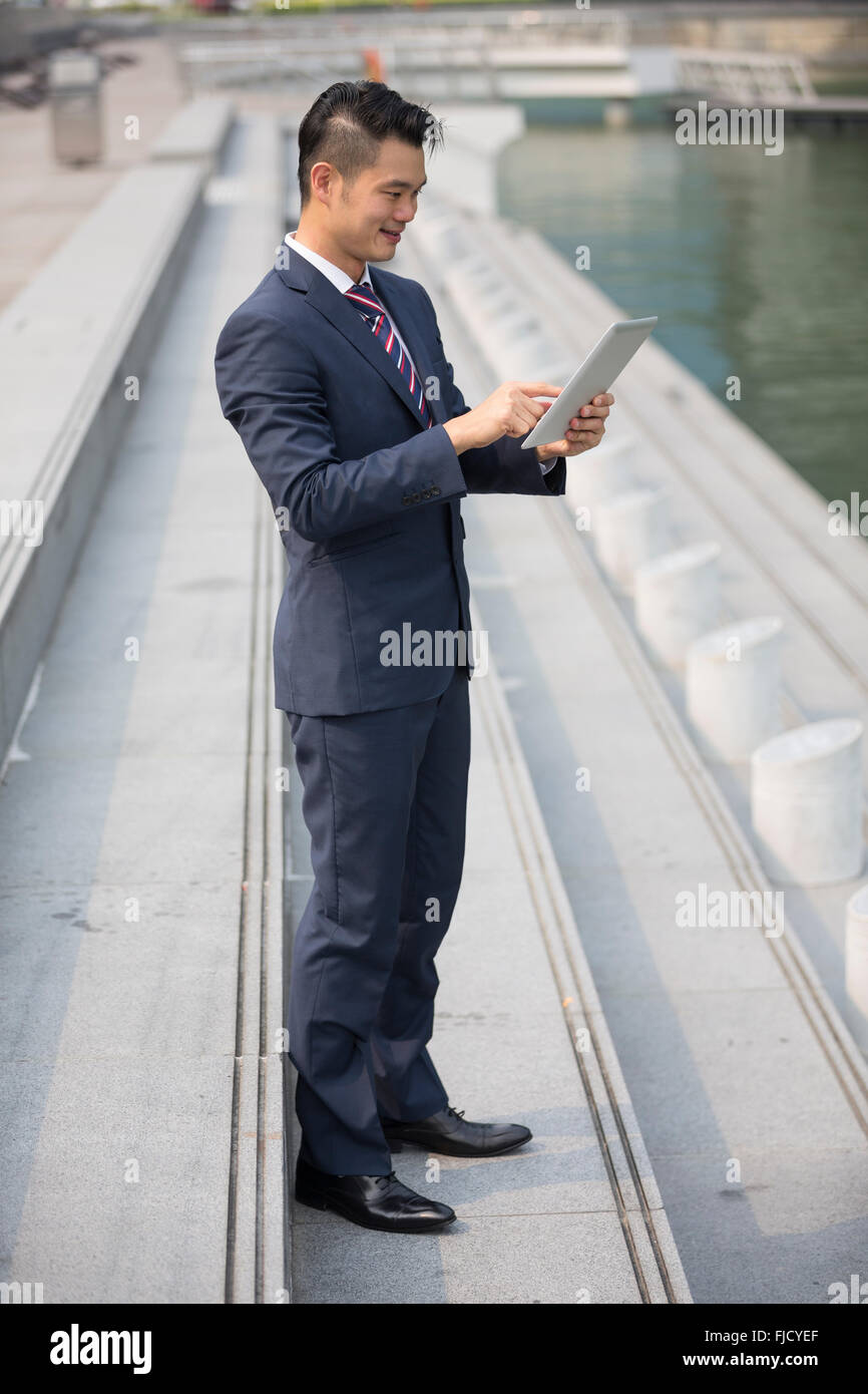 Chinesischer Mann mit einem Tabletcomputer. Asiatische Geschäftsmann mit digitalen Tablettcomputer. Stockfoto