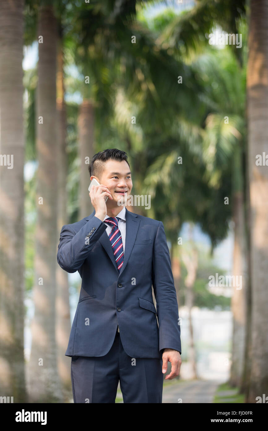 Ein glücklich chinesischen Geschäftsmann mit seinem Smartphone. Stockfoto