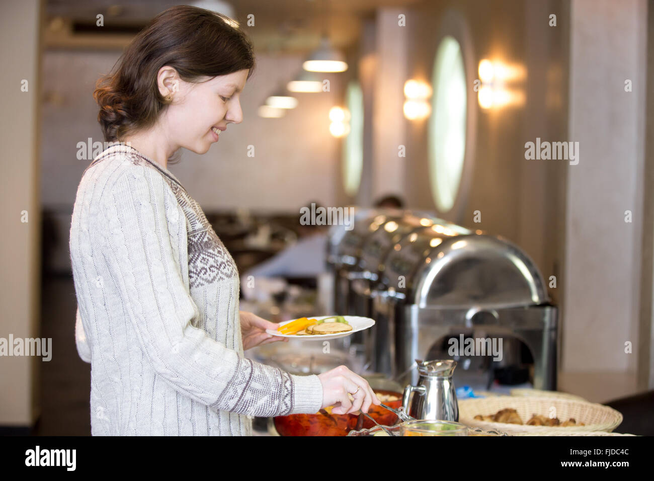 Porträt des jungen glücklich lächelnde Frau bekommen zur Selbstverpflegung Frühstück im Hotelrestaurant Stockfoto