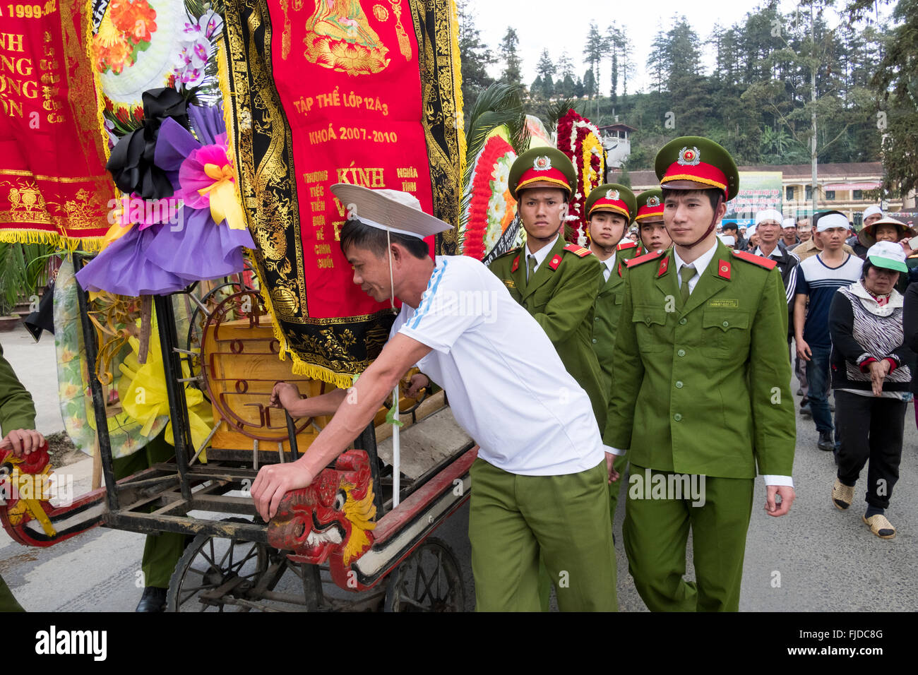 Trauernden folgen einen Sarg auf einem taoistischen Trauerzug in den Straßen von Sapa in Nordvietnam Stockfoto