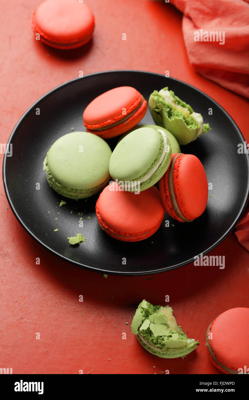 rote und grüne Makronen auf Teller, Essen Nahaufnahme Stockfoto