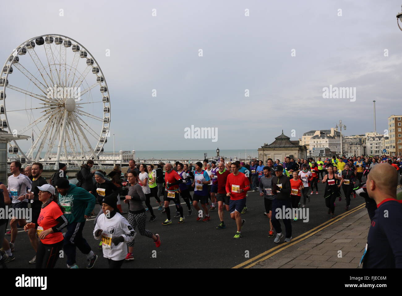 Brighton-Halbmarathon-Läufer mit dem Rad und dem Pier im Hintergrund. Stockfoto