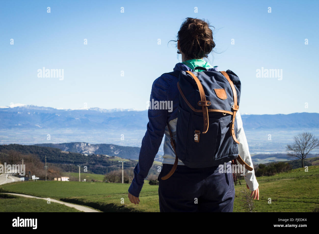 Junge Frau Wanderer über blauen Himmel und schneebedeckten Gipfeln Stockfoto