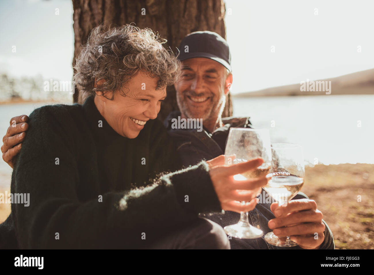 Porträt des entspannten Reife Paare, ein Glas Wein am Campingplatz. Ältere Mann und Frau Toasten Wein im Sommer Tag. Stockfoto