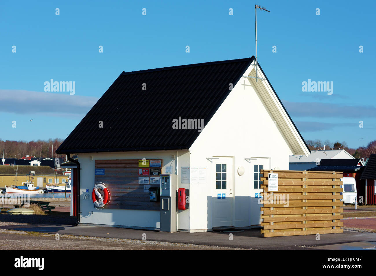 Nogersund, Schweden - 27. Februar 2016: Die kleine Toilette Gebäude neben dem Areal im Hafen. Hier befindet sich auch ein Pay-statio Stockfoto