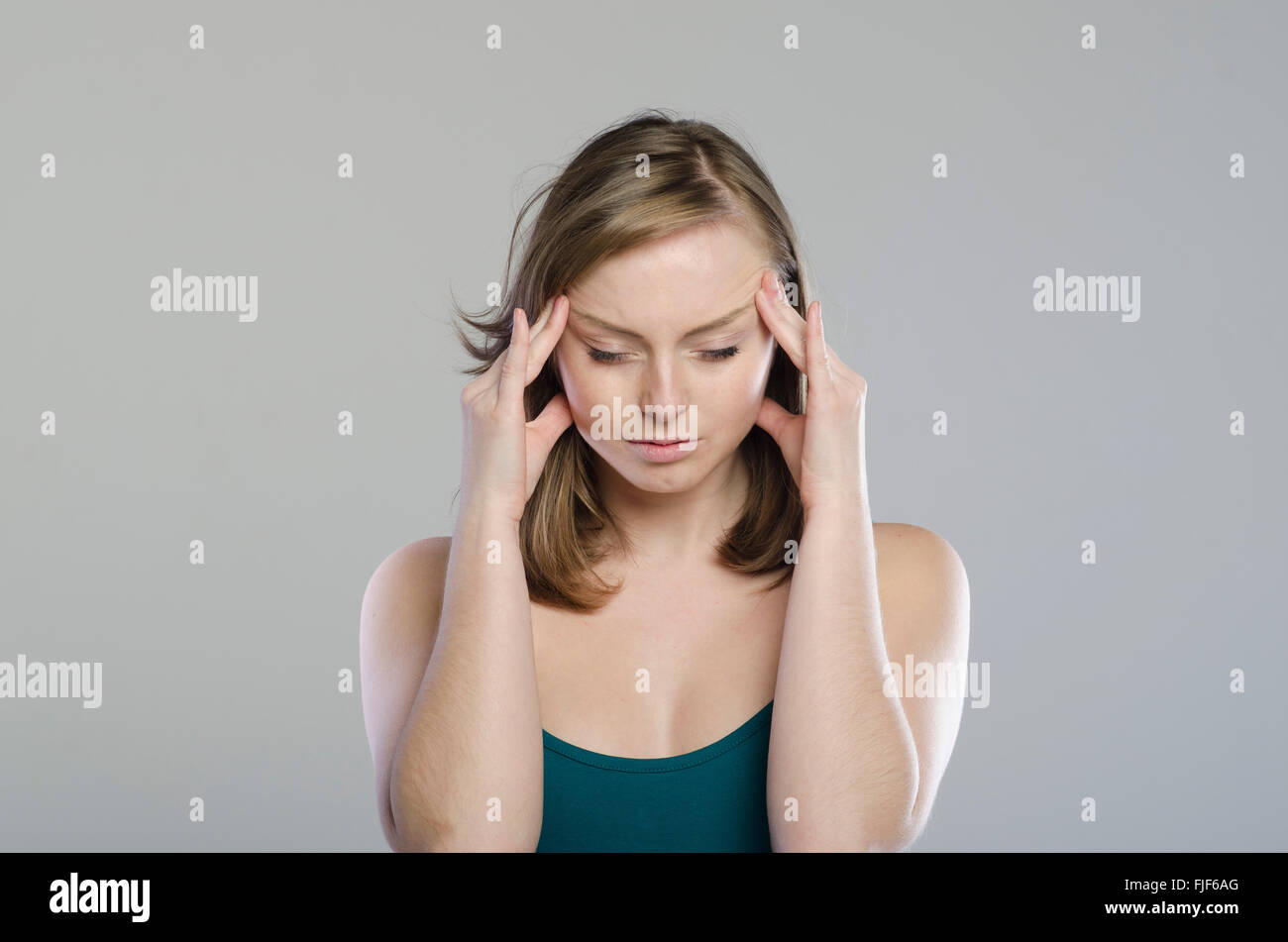 Junge Frau massiert ihre Tempel Stockfoto