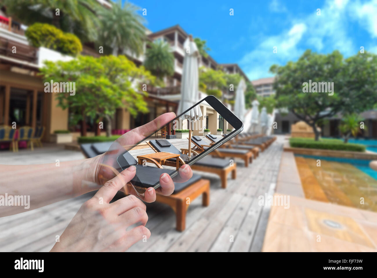 Doppelbelichtung weibliche Hand halten und Touch Screen Smartphone, Tablet, Handy Trestle-Betten und weißen Sonnenschirmen in der Nähe von re Stockfoto