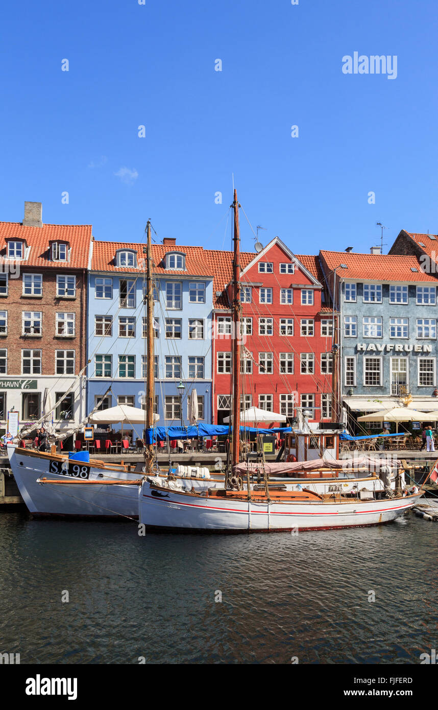 Alte hölzerne Boote vertäut am Kai Kanal mit bunten Gebäude an der Uferpromenade in Nyhavn Kopenhagen Dänemark Skandinavien Stockfoto