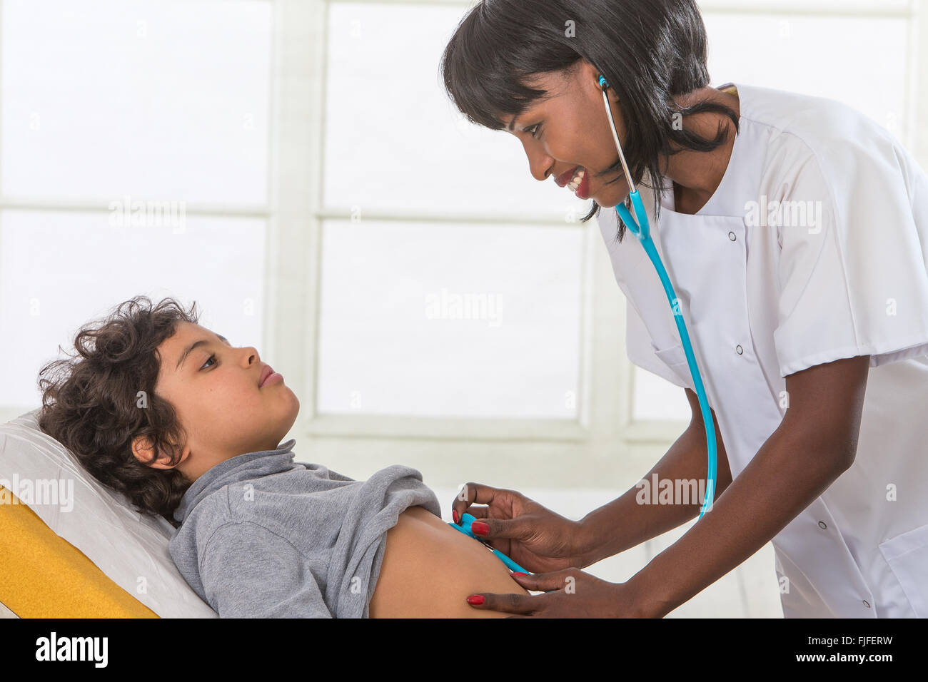 Gesundheit der Arbeitnehmer hört Lungen der jungen Patienten im Prüfungsraum Stockfoto