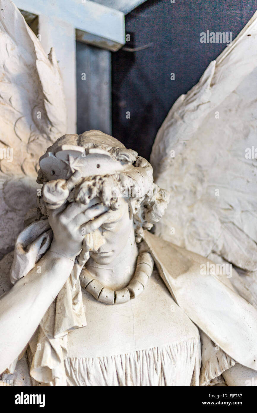 bestäubt Statue der weinenden Engel hält seinen Kopf während Tränen fließt auf Nase Stockfoto