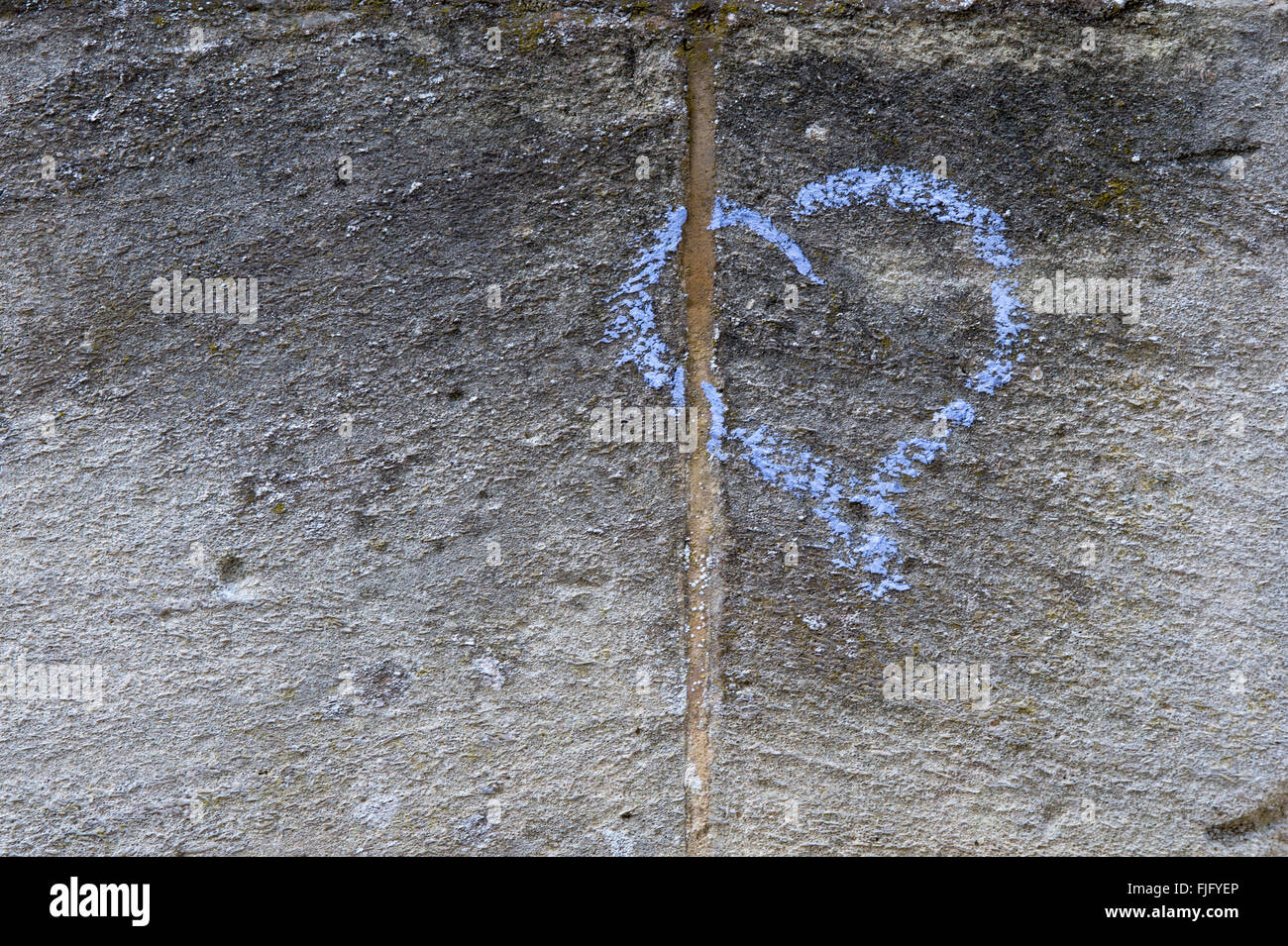 Blaue Kreide Liebe Herz auf einer Steinmauer Stockfoto
