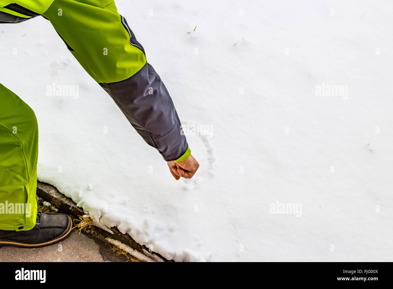 Hand eines Mannes, der in den Schnee zeichnen Stockfoto