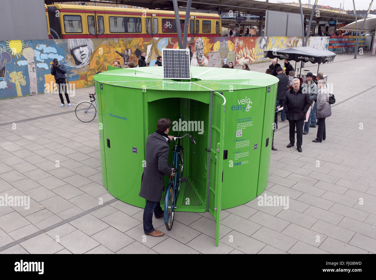 Berlin, Deutschland. 2. März 2016. Ein Radfahrer schiebt sein Fahrrad in ein abschließbarer Fahrrad-Aufbewahrungsbox vor Bahnhof Lichtenberg in Berlin, Deutschland, 2. März 2016. Operator Velo einfach sagen, dass 250 Speicherplätze für 2016 geplant sind. Ein Turm bietet Platz für 10 Fahrräder, inklusive Helm und Rucksack. Die Räume Kabine buchbar über eine Smartphone-App Foto: RAINER JENSEN/DPA/Alamy Live News Stockfoto