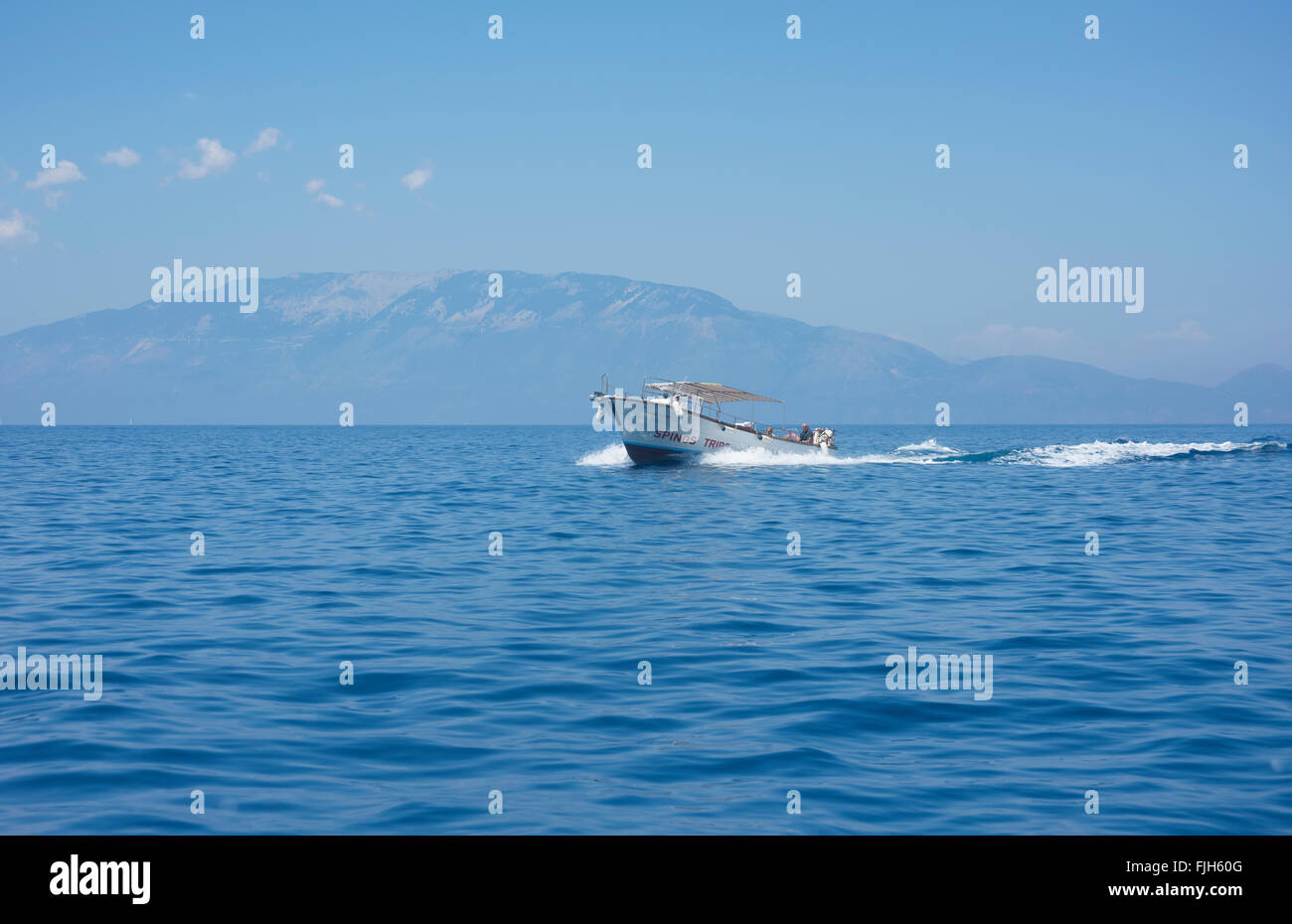 Motorboot im Ionischen Meer vor der Küste von Zakynthos in Griechenland, mit der Insel Kefalonia in der Ferne Stockfoto