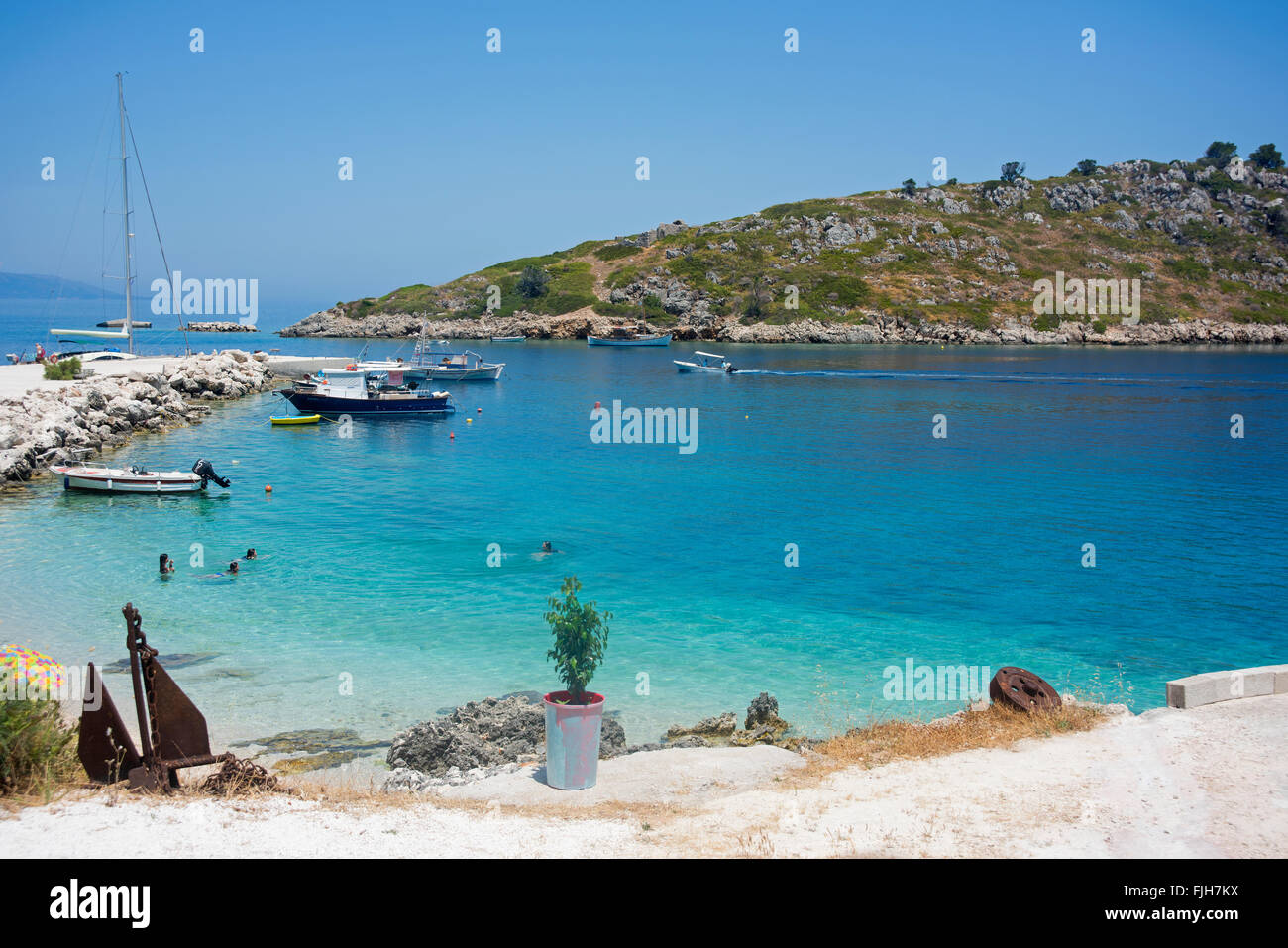 Menschen schwimmen im türkisblauen Wasser in Agios Nikolaos, auf der Insel Zakynthos in Griechenland Stockfoto