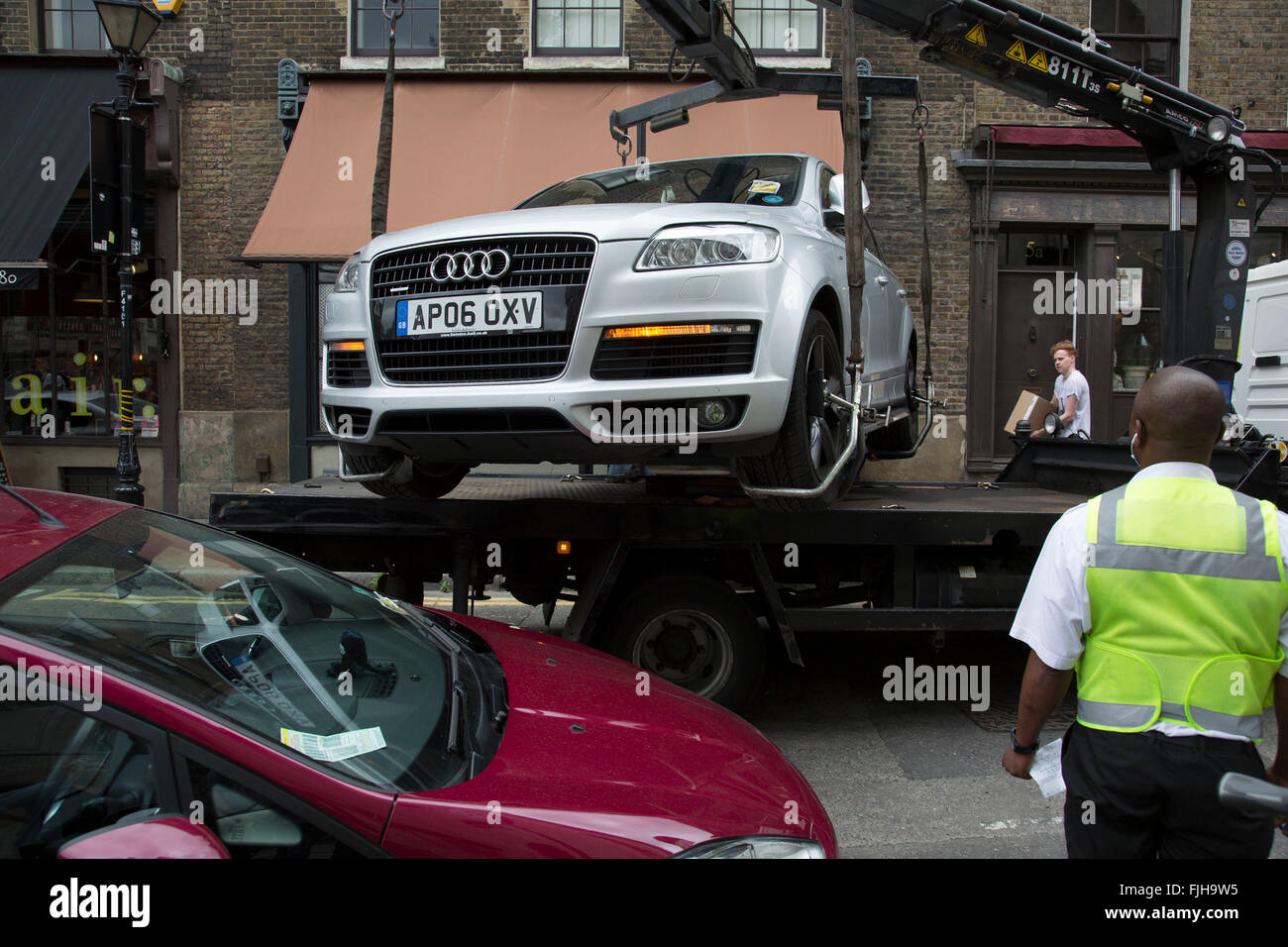 Auto wird auf der Rückseite eines LKW gehoben und beschlagnahmt von zugelassenen Durchsetzung Einheit für illegale Parkplatz in Spitalfields, London, UK. Nicht Parkplatz Geldbußen, entfernt diese Abteilung illegal geparkten Fahrzeug. Stockfoto