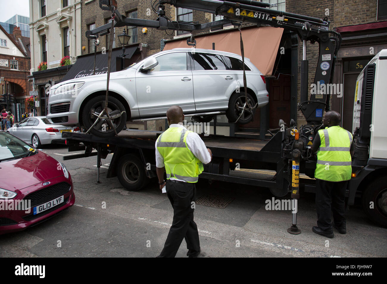 Auto wird auf der Rückseite eines LKW gehoben und beschlagnahmt von zugelassenen Durchsetzung Einheit für illegale Parkplatz in Spitalfields, London, UK. Nicht Parkplatz Geldbußen, entfernt diese Abteilung illegal geparkten Fahrzeug. Stockfoto
