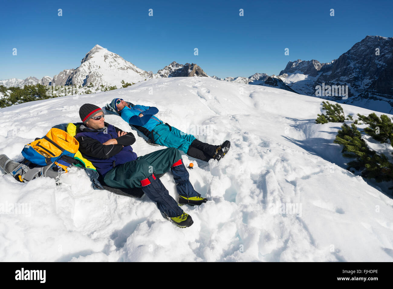 Bergsteiger sitzt auf einem Berg im Schnee Piste und nehmen ein Sonnenbad, Karwendel, Tirol, Österreich Stockfoto