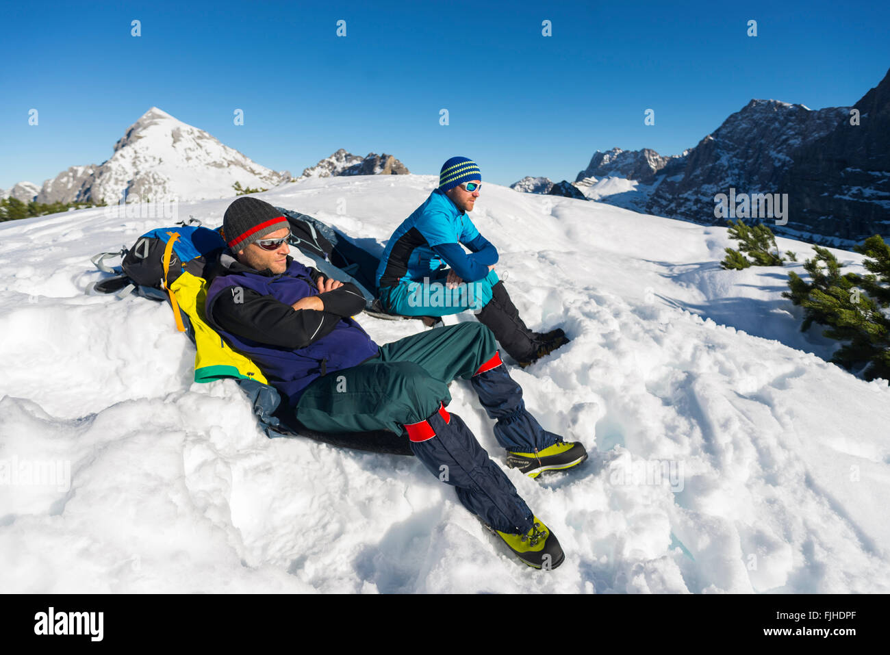 Bergsteiger sitzt auf einem Berg im Schnee Piste und nehmen ein Sonnenbad, Karwendel, Tirol, Österreich Stockfoto