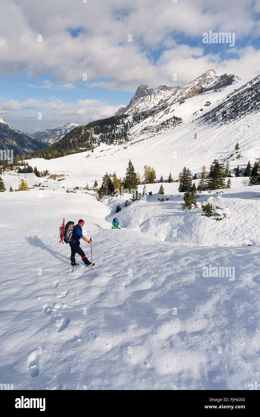 Wanderer beim Abstieg des Falken Hütte zur Alp Ladiz über Schneefelder im Sonnenlicht, Karwendel, Tirol, Österreich Stockfoto