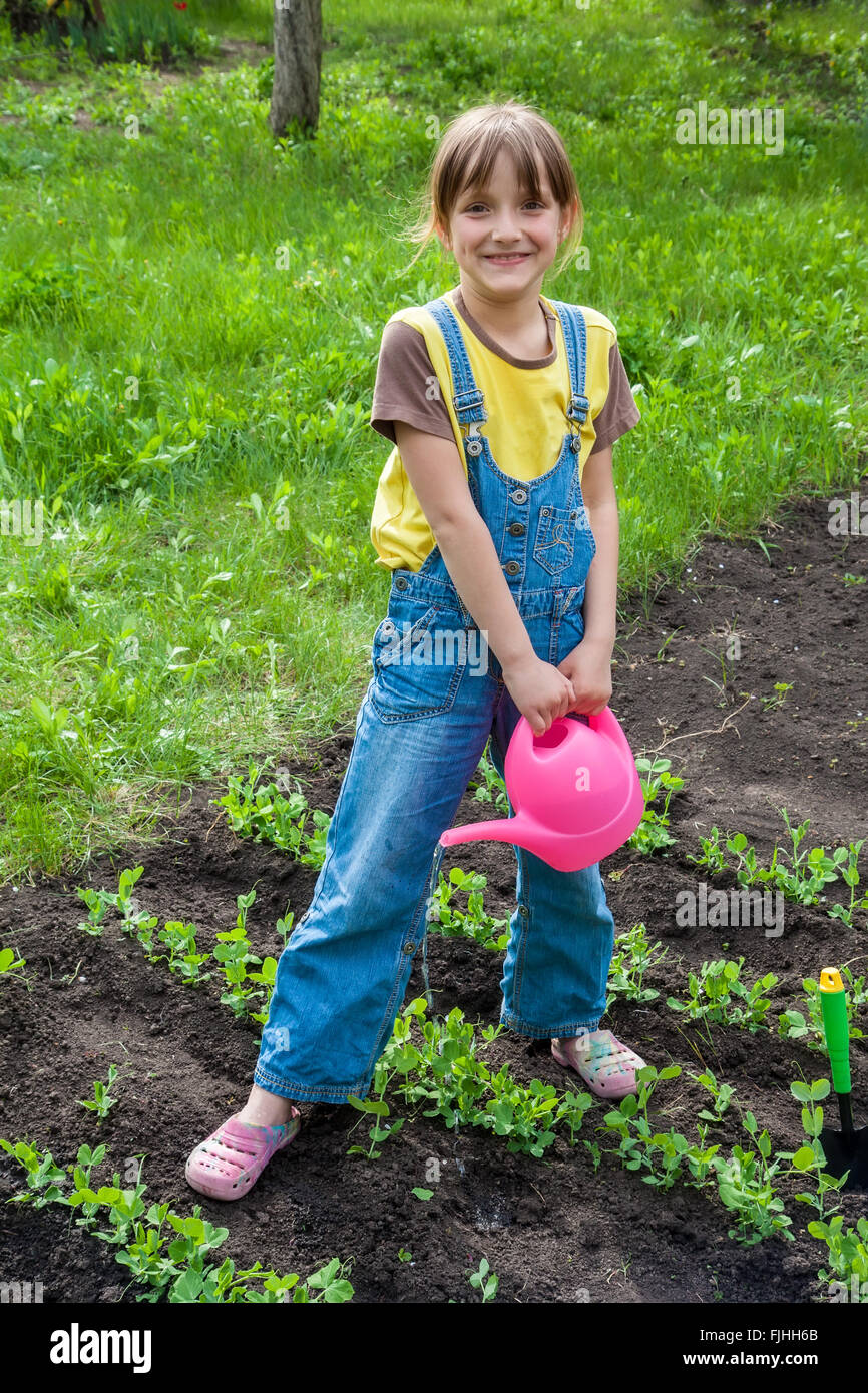 kleines Mädchen im Garten mit Pflanzen Stockfoto