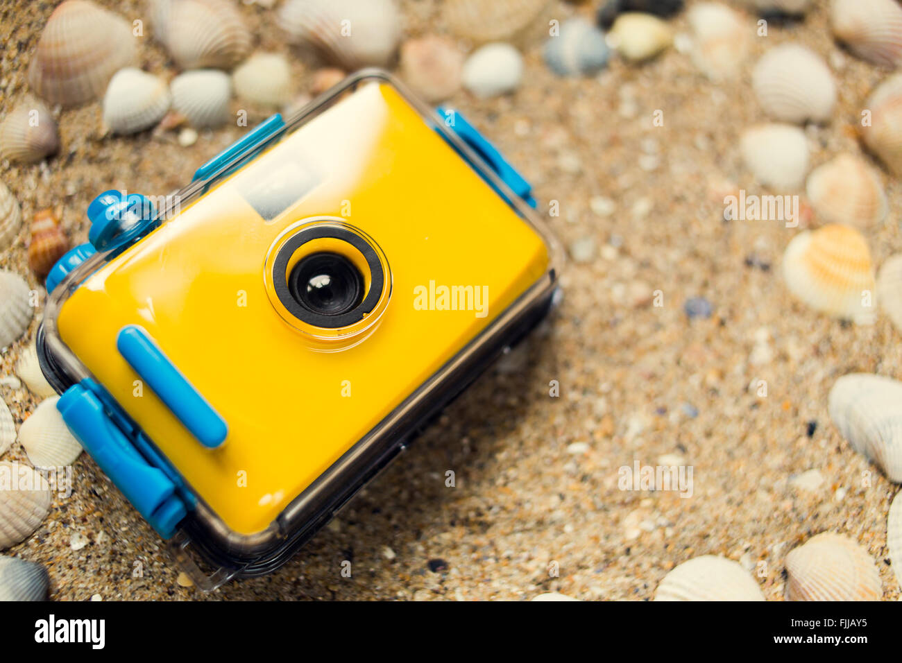 Gelbe Kamera auf Sand am Strand Stockfoto