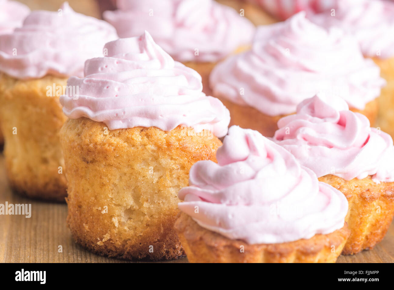 hausgemachte Kuchen mit rosa Creme auf dem Holztisch Stockfoto