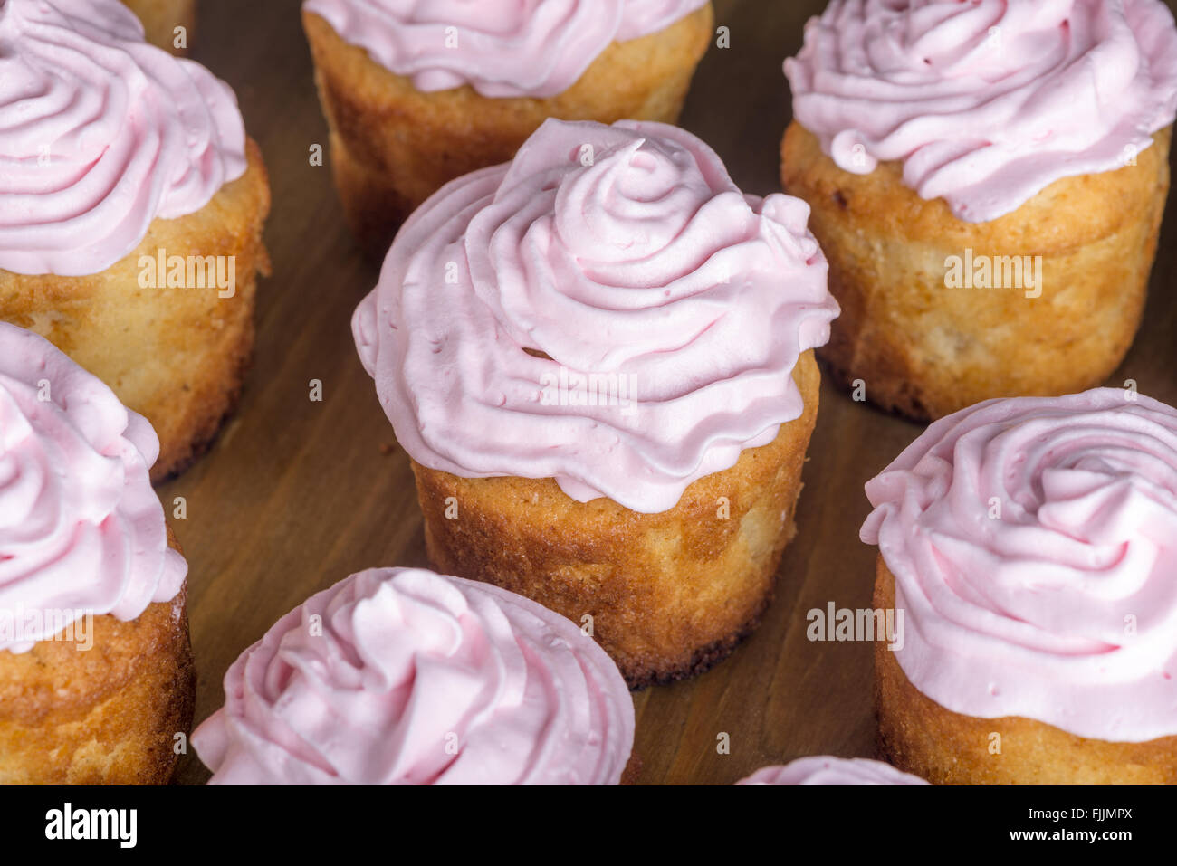 hausgemachte Kuchen mit rosa Creme auf dem Holztisch Stockfoto