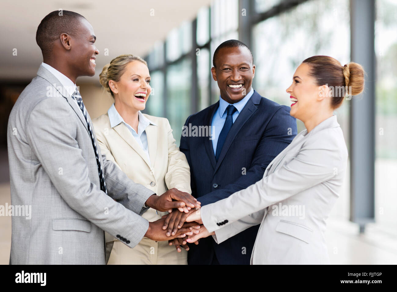 fröhliche multirassische Business-Team setzen ihre Hände zusammen Stockfoto
