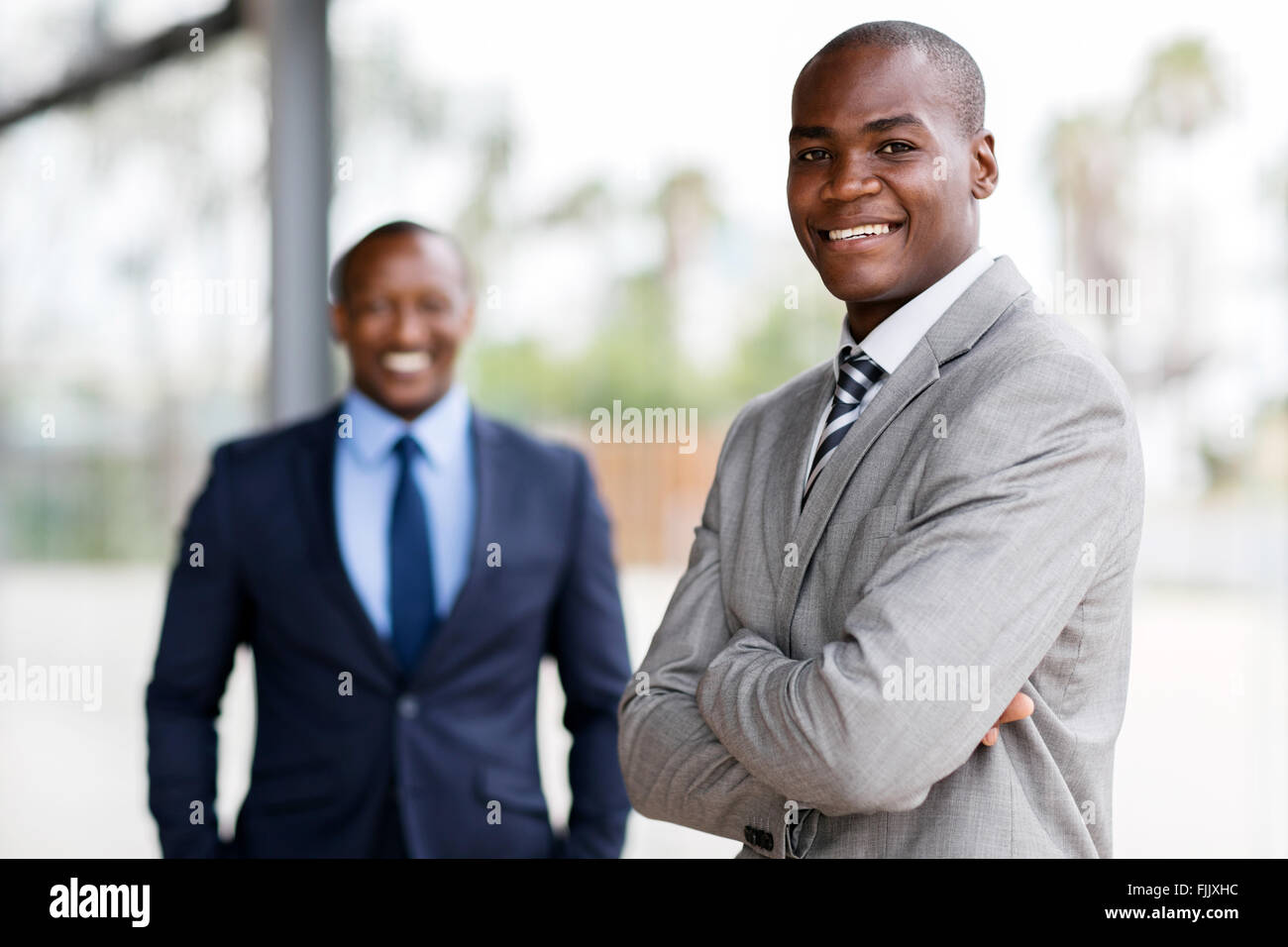 gut aussehende Afro amerikanische Geschäftsmann mit Kollegen auf Hintergrund Stockfoto