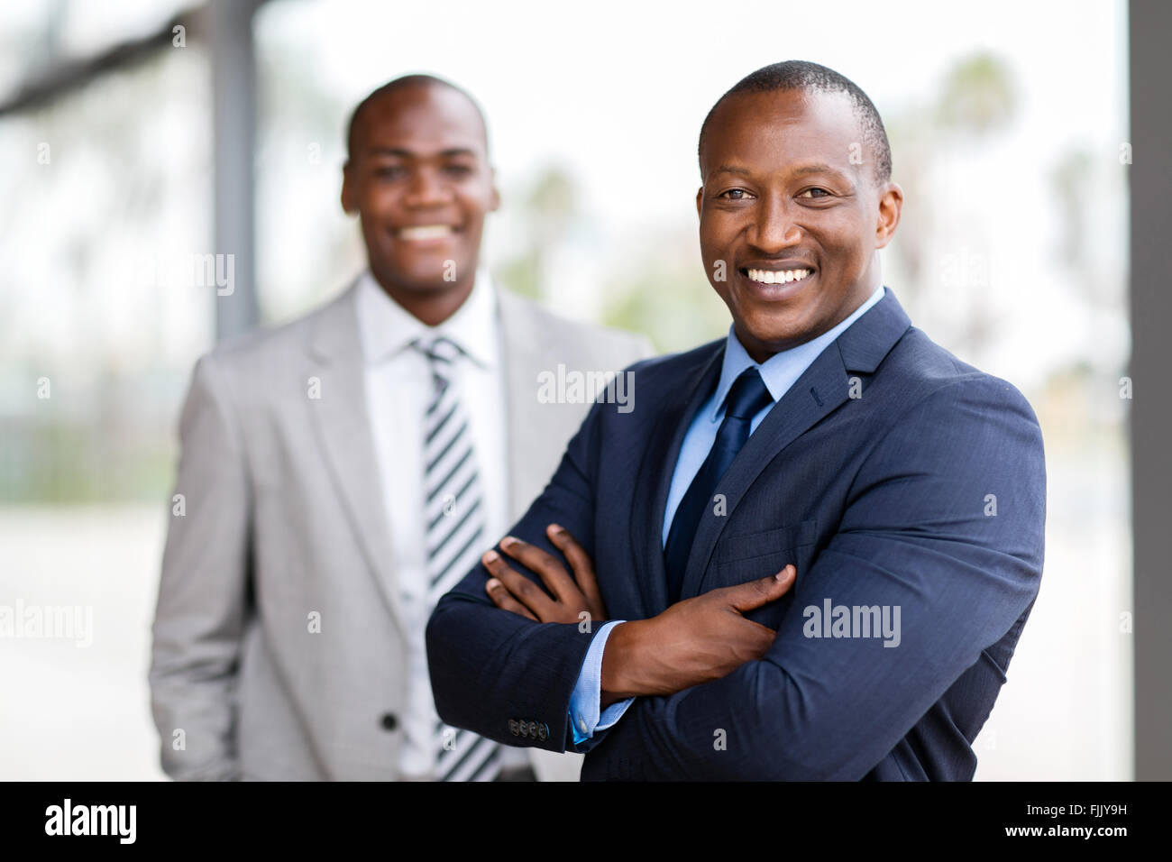 fröhlichen afrikanischen Geschäftsmann vor Kollegen Stockfoto
