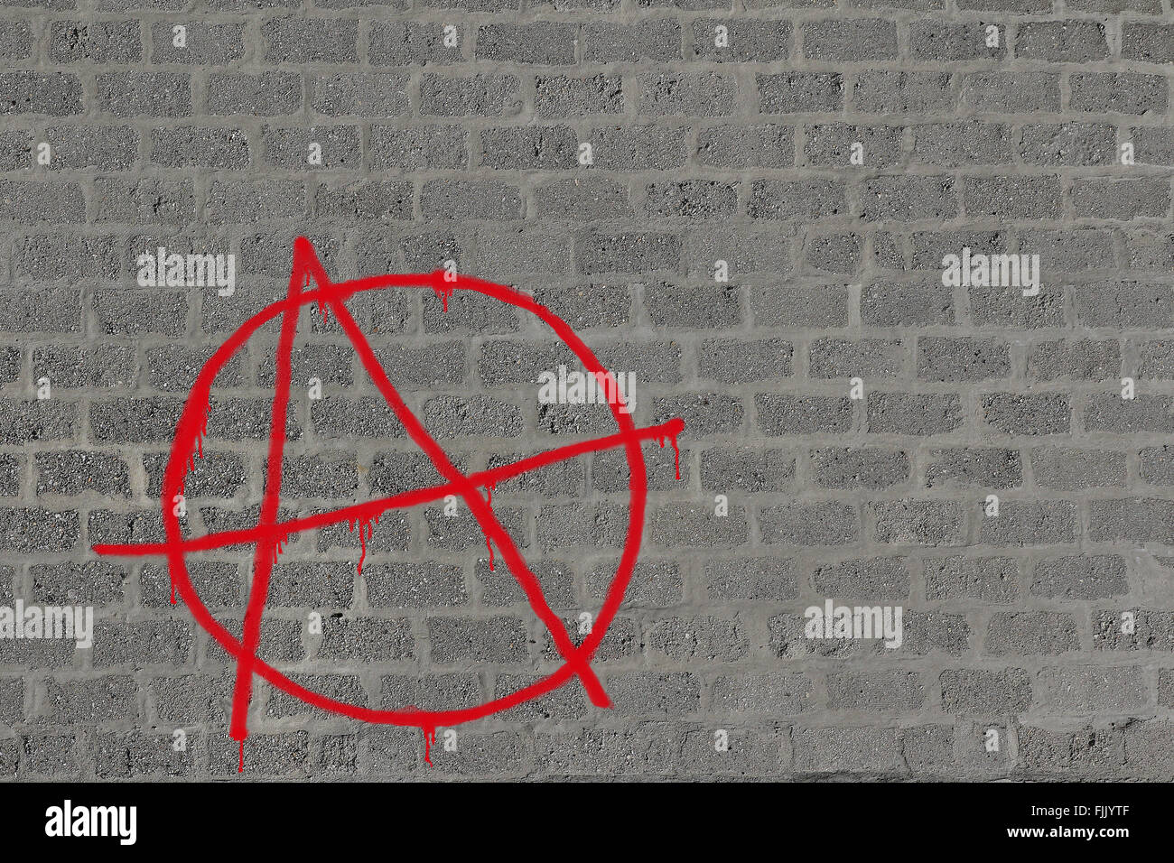 Betonblock Wand mit Anarchie in rot aufgesprüht in rot, Abbildung Stockfoto