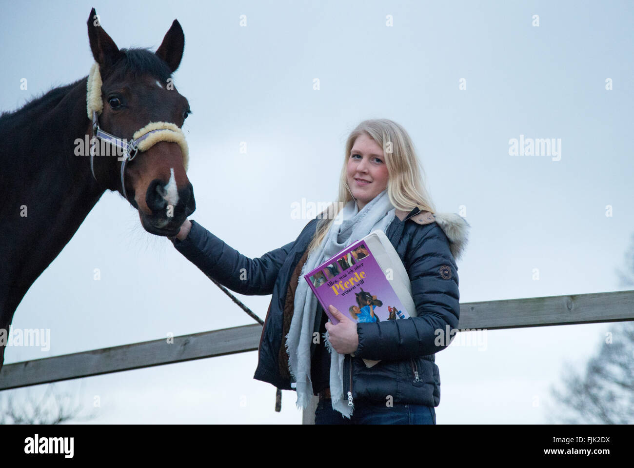 Ankum, Deutschland. 24. Februar 2016. Schülerin Hanna Lagemann Trainingsmaterial aus ihrer Schule neben ihrem Pferd in Ankum, Deutschland, 24. Februar 2016 halten. Hanna nahm Pferdesport Voltigieren als Prüfung Fach für Abitur (A-Level). Foto: FRISO GENTSCH/DPA/Alamy Live-Nachrichten Stockfoto Ankum, Deutschland. 24. Februar 2016. Schülerin Hanna Lagemann Trainingsmaterial aus ihrer Schule neben ihrem Pferd in Ankum, Deutschland, 24. Februar 2016 halten. Hanna nahm Pferdesport Voltigieren als Prüfung Fach für Abitur (A-Level). Foto: FRISO GENTSCH/DPA/Alamy Live-Nachrichten Stockfoto