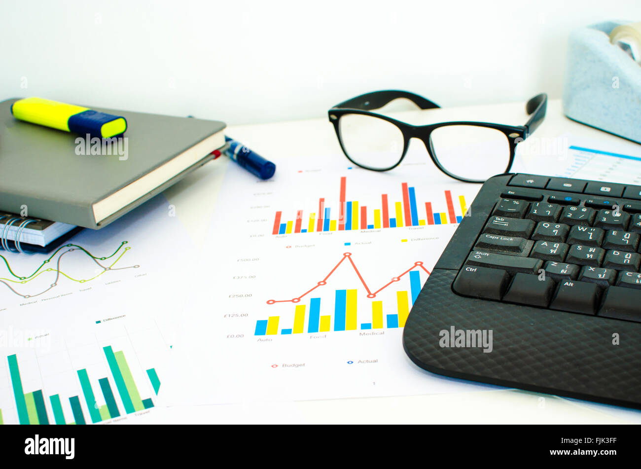 Laptop und Stift mit Business Diagramme, Grafiken, Statistiken und Dokumente Stockfoto